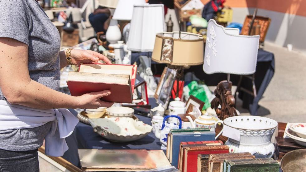 Person reading book at a car boot sale